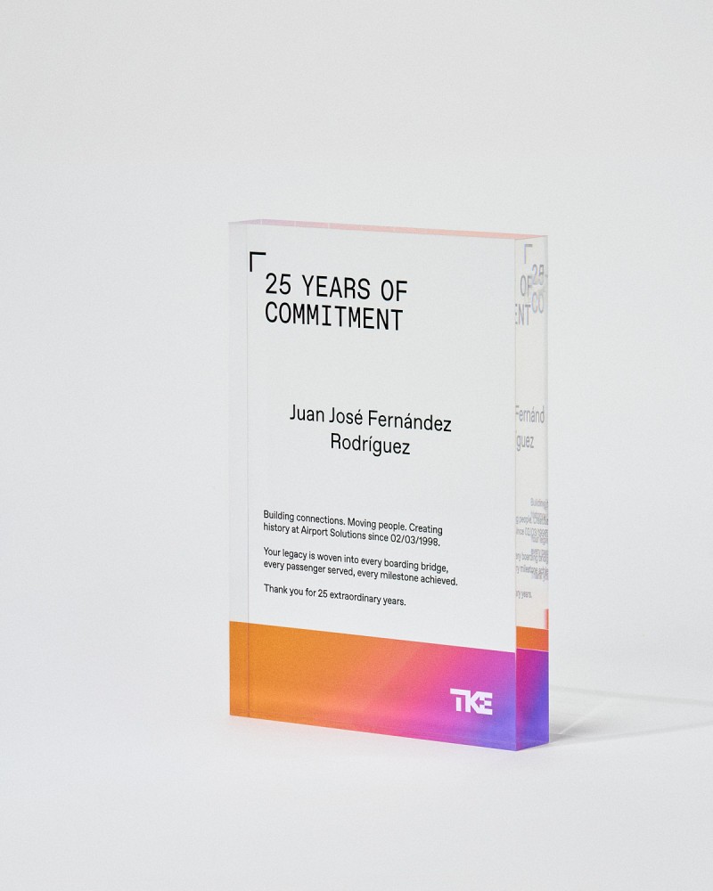 Trophée en plexiglas format plaque VITRA A5 à personnaliser, tenu par une mannequin, Sustain Awards 2