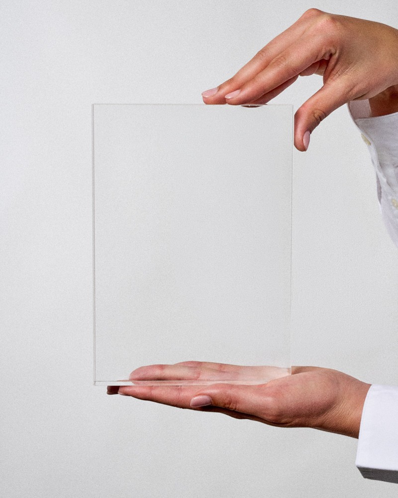 Trophée en plexiglas format plaque VITRA A5 à personnaliser, tenu par une mannequin, Sustain Awards